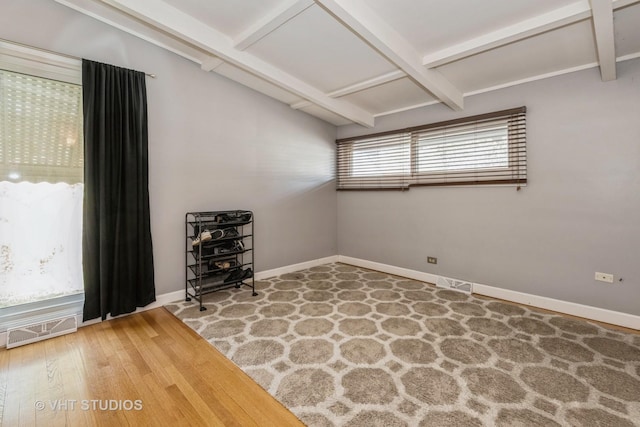 empty room featuring hardwood / wood-style floors, beamed ceiling, and coffered ceiling