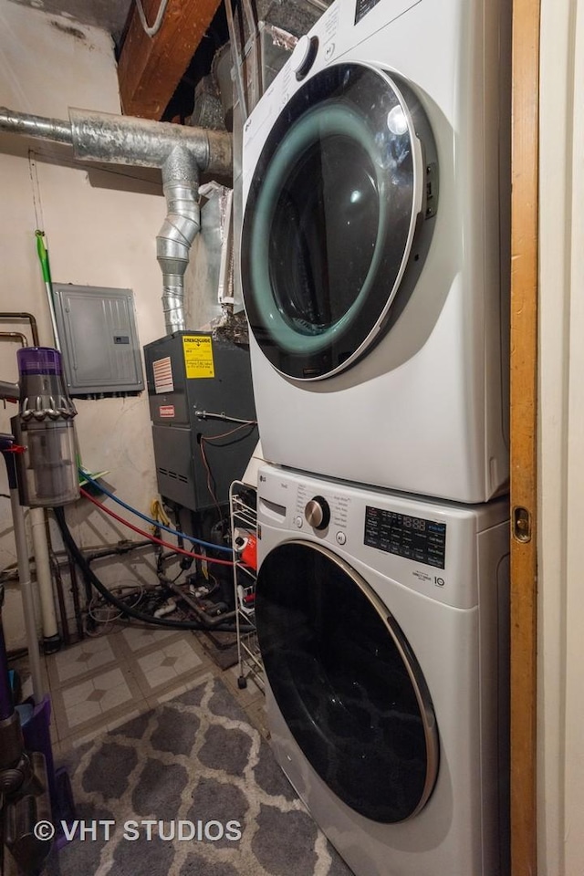 clothes washing area featuring stacked washing maching and dryer and electric panel