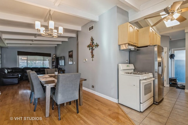 dining area with lofted ceiling with beams, ceiling fan with notable chandelier, and light hardwood / wood-style floors