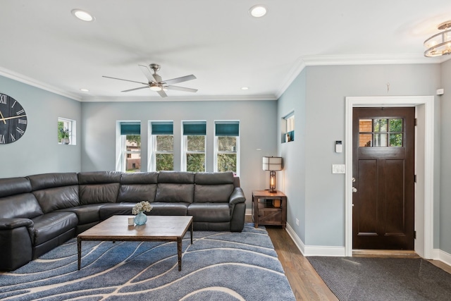 living room featuring dark hardwood / wood-style floors, a healthy amount of sunlight, ornamental molding, and ceiling fan