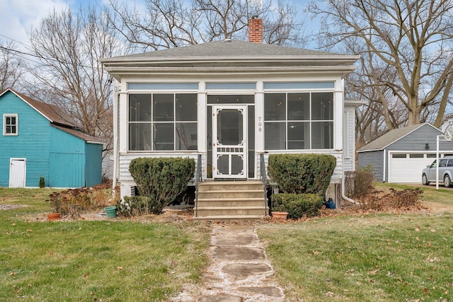 view of front of property featuring a front lawn and an outdoor structure