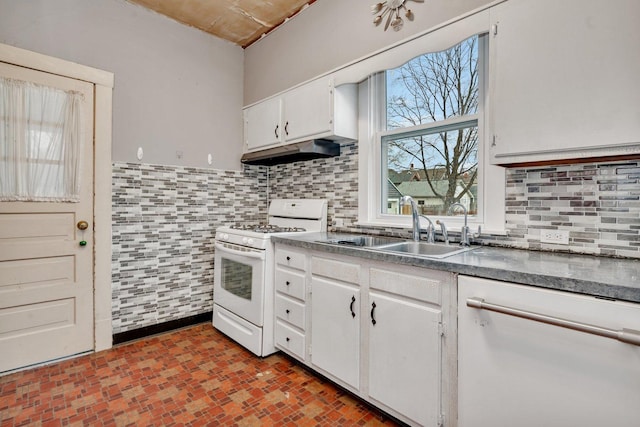 kitchen featuring white gas range oven, backsplash, white cabinetry, and sink