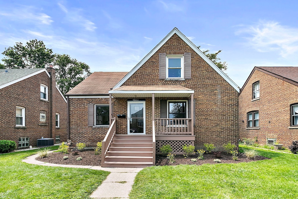 view of front of home featuring central AC unit, covered porch, and a front yard