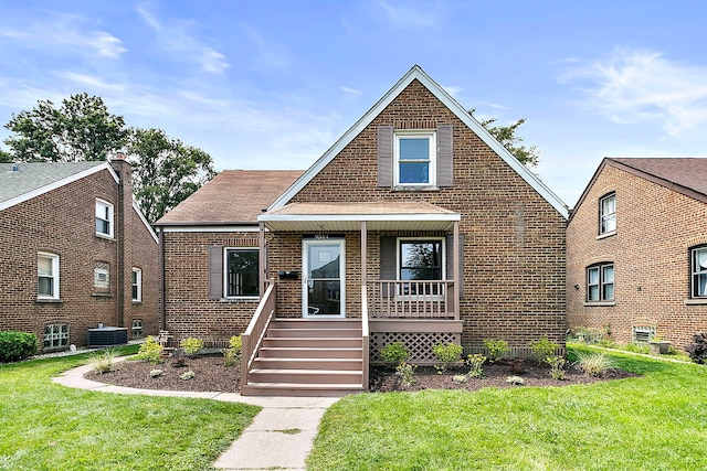 view of front of home featuring central AC unit, covered porch, and a front yard