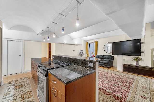 kitchen featuring stainless steel electric stove, pendant lighting, a kitchen island, and dark stone counters