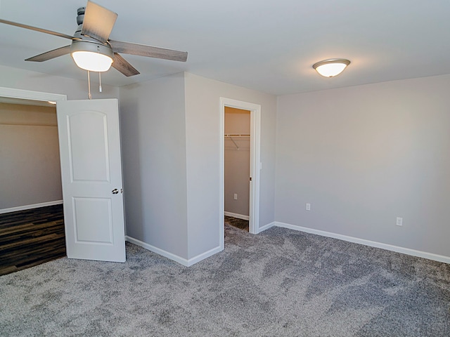 unfurnished bedroom with ceiling fan, a closet, carpet, and a spacious closet