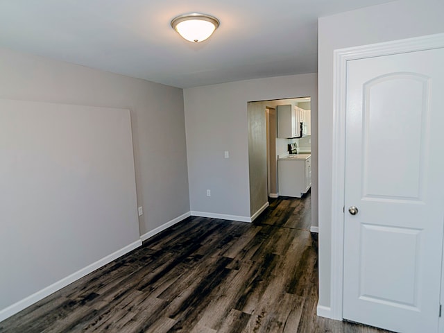 empty room featuring washer / clothes dryer and dark wood-type flooring