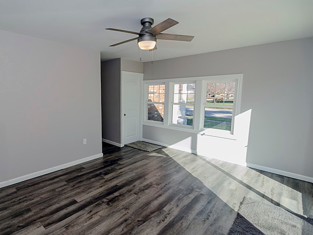 empty room featuring ceiling fan and dark wood-type flooring