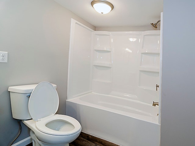 bathroom featuring hardwood / wood-style floors, bathtub / shower combination, and toilet