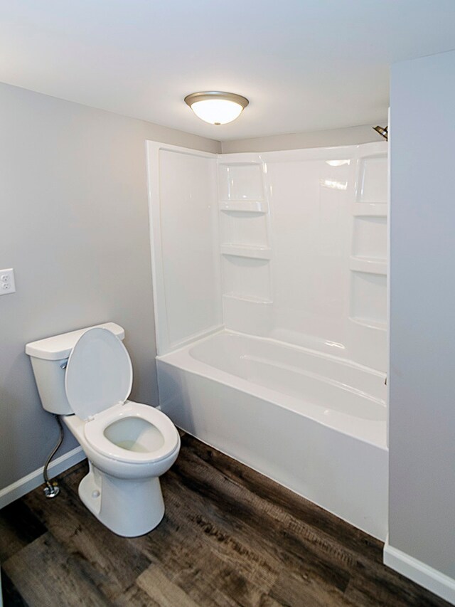 bathroom featuring bathtub / shower combination, wood-type flooring, and toilet