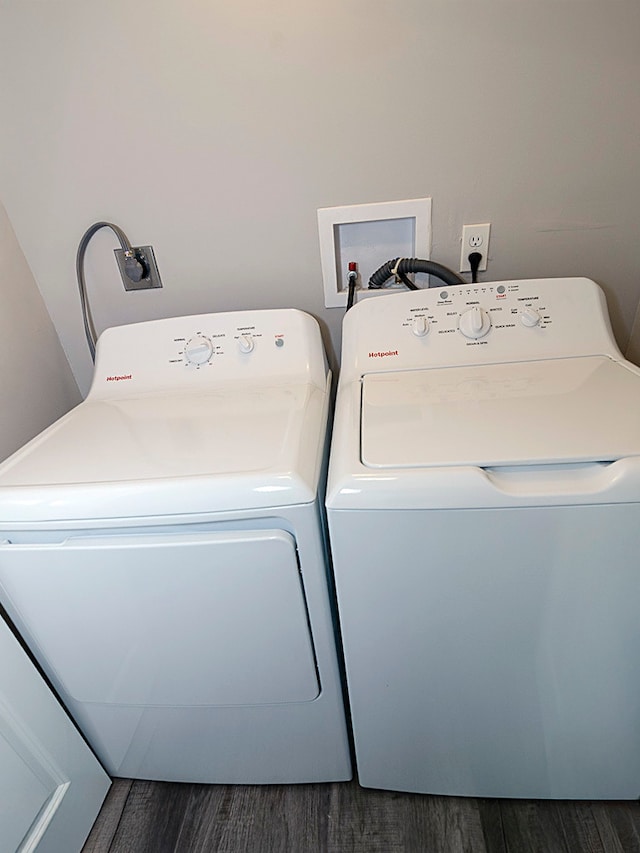 washroom with dark wood-type flooring and independent washer and dryer