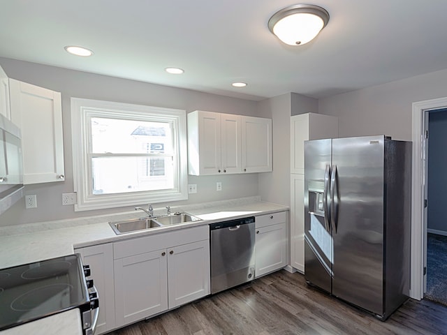 kitchen with white cabinets, sink, stainless steel appliances, and dark wood-type flooring