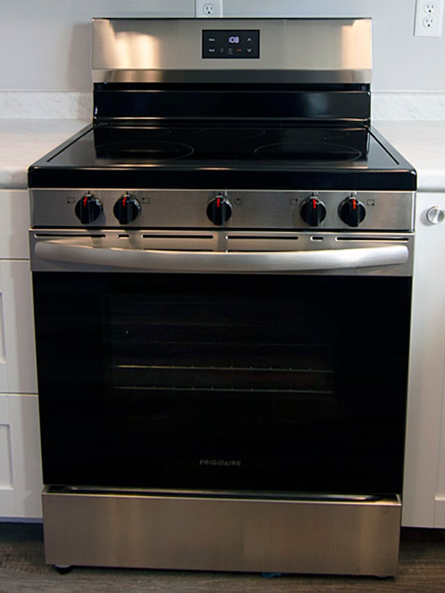 details with dark hardwood / wood-style flooring and stainless steel range