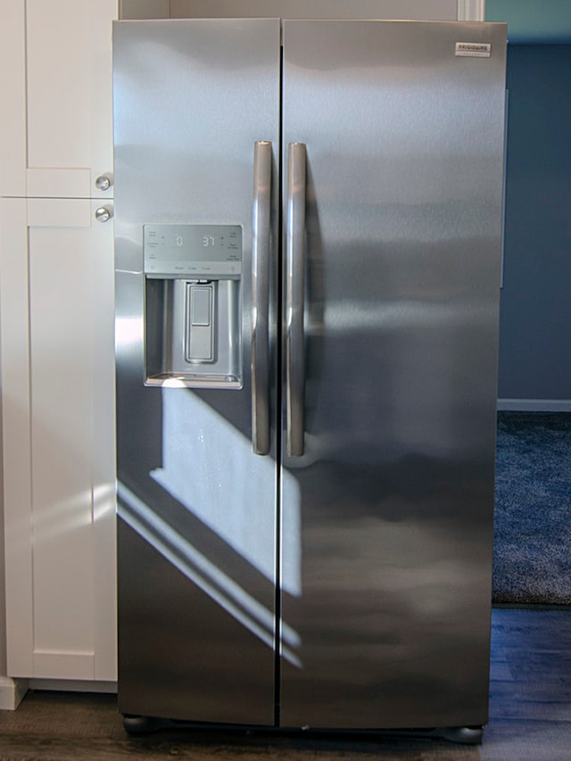 interior details featuring white cabinetry, stainless steel fridge with ice dispenser, and dark hardwood / wood-style flooring