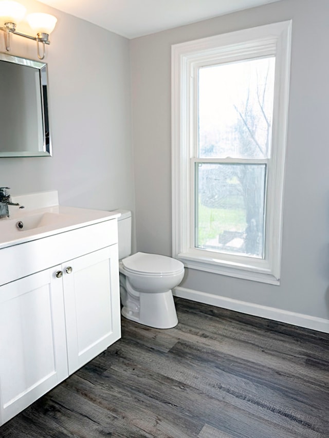 bathroom featuring toilet, vanity, and hardwood / wood-style flooring