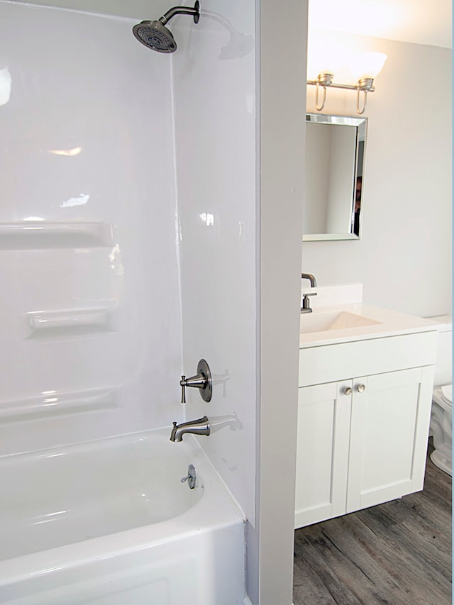 full bathroom featuring shower / bathing tub combination, hardwood / wood-style floors, vanity, and toilet