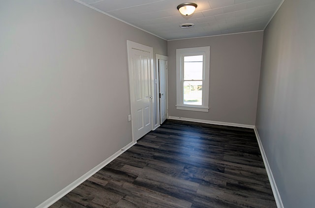 empty room featuring dark hardwood / wood-style floors and ornamental molding