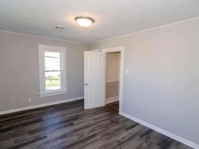 empty room featuring crown molding and dark hardwood / wood-style floors