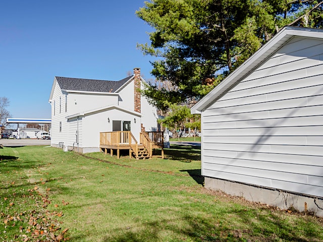 rear view of house featuring a yard and a deck