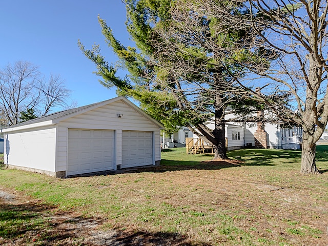 view of yard with a garage and an outbuilding