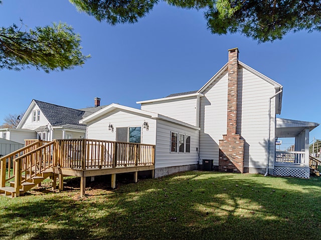 rear view of house with a deck, a yard, and central air condition unit