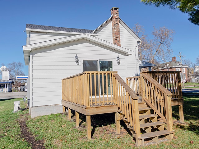 rear view of house featuring a yard and a deck