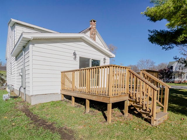 back of property featuring a lawn and a wooden deck