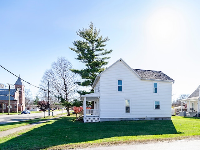 view of side of home featuring a yard and a porch