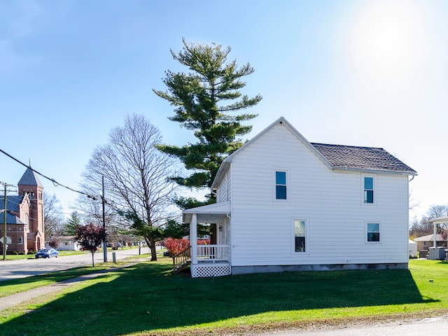 view of side of home featuring a porch and a yard