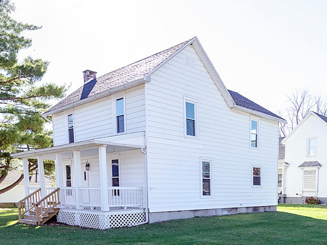 back of property featuring a porch and a lawn