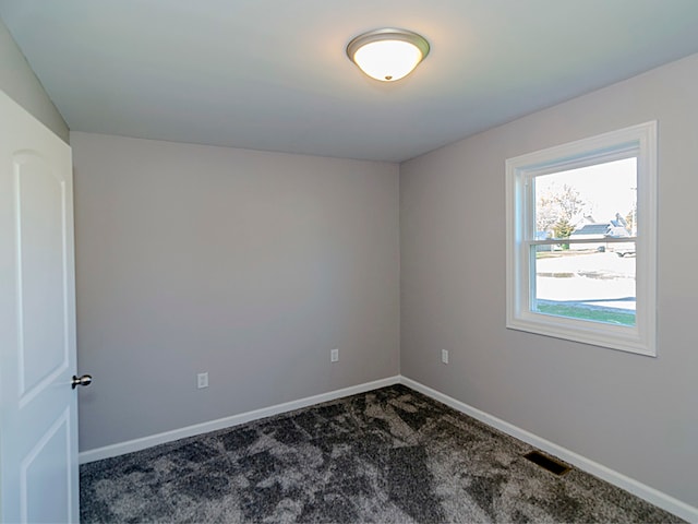 empty room with dark colored carpet