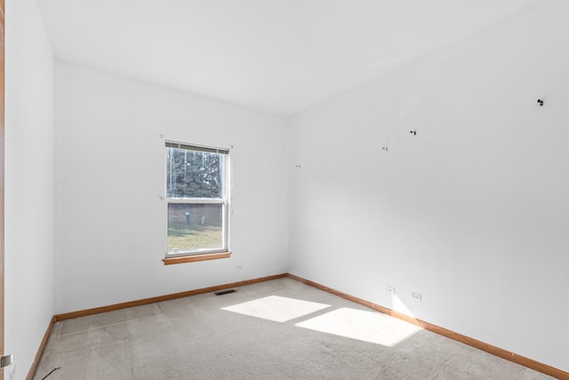 empty room with light carpet, visible vents, and baseboards