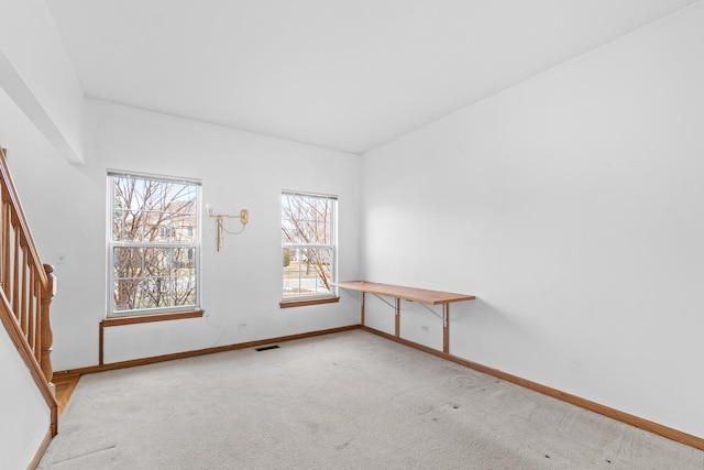 spare room with stairs, carpet, visible vents, and baseboards