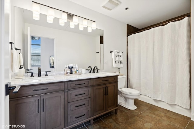 full bathroom featuring visible vents, double vanity, a sink, and toilet