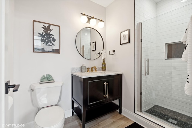 full bathroom featuring vanity, wood finished floors, a shower stall, and toilet