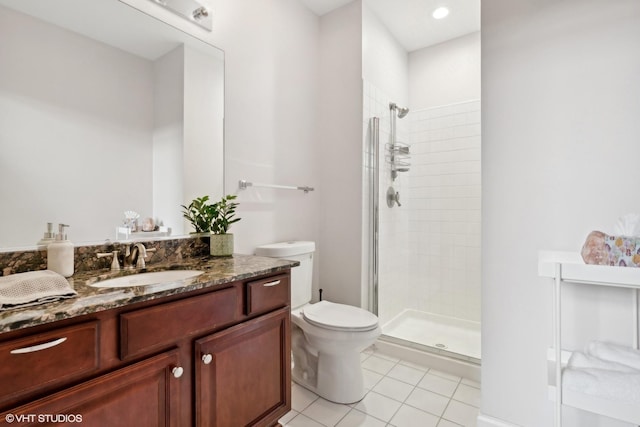 bathroom with a stall shower, vanity, toilet, and tile patterned floors