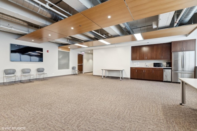 interior space with light carpet, freestanding refrigerator, and baseboards