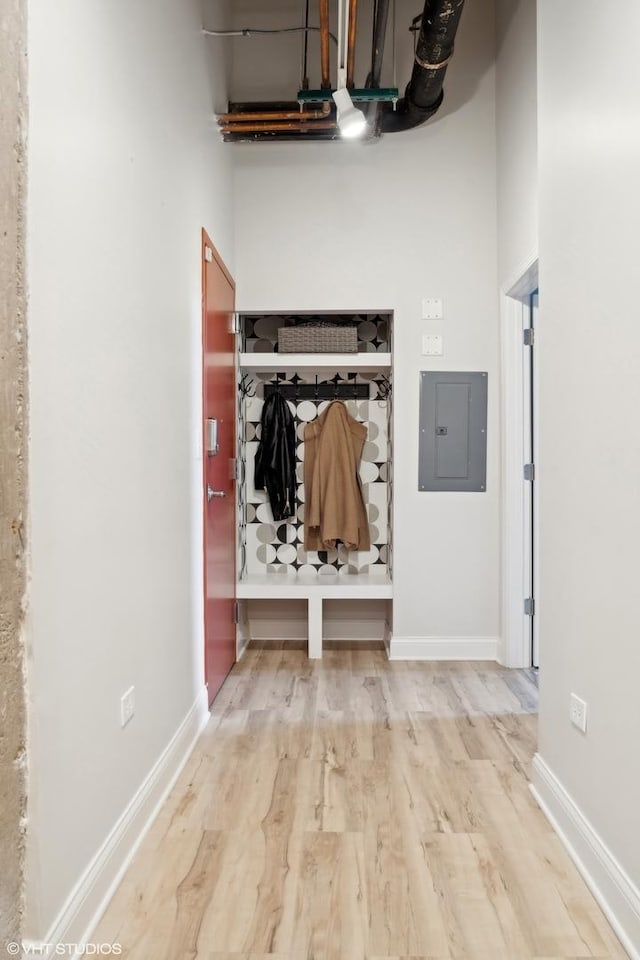 mudroom with electric panel, baseboards, and wood finished floors