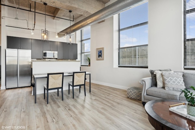 kitchen with stainless steel appliances, hanging light fixtures, visible vents, and light wood-style floors