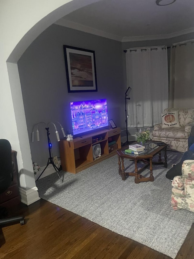 living room with wood-type flooring and ornamental molding