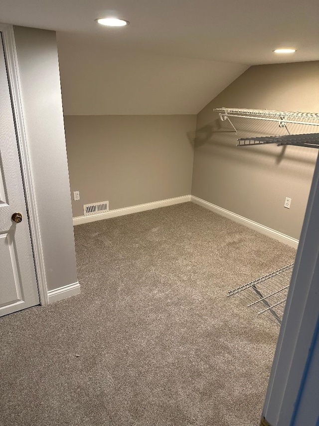 walk in closet featuring carpet floors and lofted ceiling