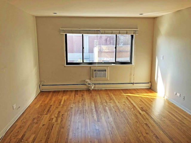 unfurnished room with a wall mounted AC, light hardwood / wood-style floors, and a baseboard radiator