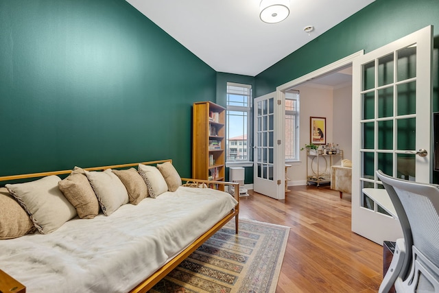 bedroom with french doors and wood-type flooring