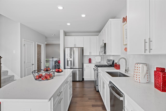 kitchen featuring sink, dark hardwood / wood-style floors, a kitchen island, white cabinetry, and stainless steel appliances