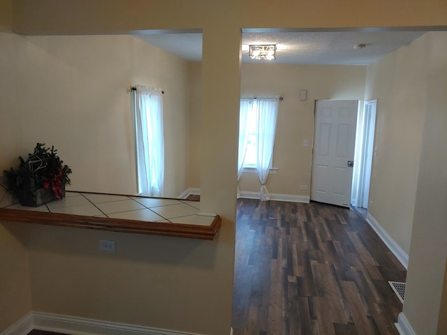 corridor featuring dark hardwood / wood-style flooring and a textured ceiling