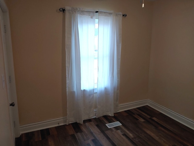 unfurnished room with dark wood-type flooring