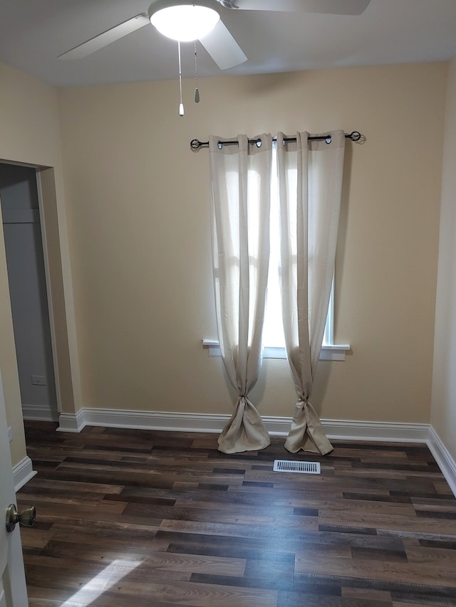 unfurnished room featuring ceiling fan and dark wood-type flooring