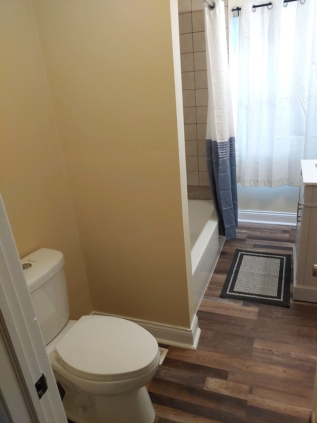 full bathroom featuring wood-type flooring, vanity, toilet, and shower / tub combo with curtain