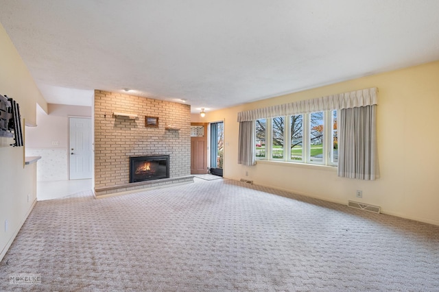 unfurnished living room with a fireplace and carpet