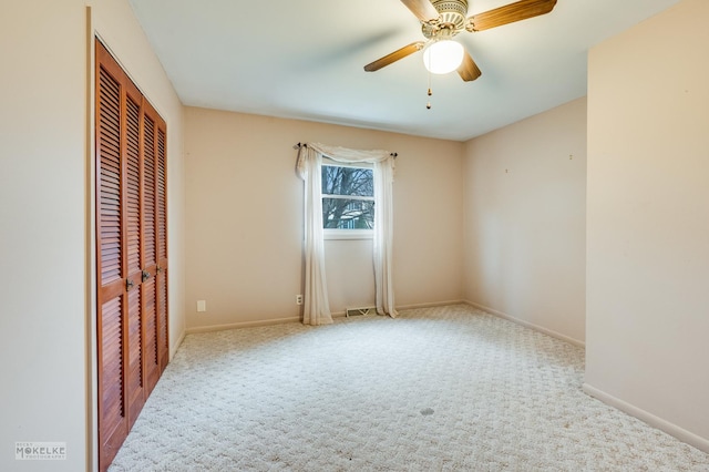 carpeted spare room with ceiling fan